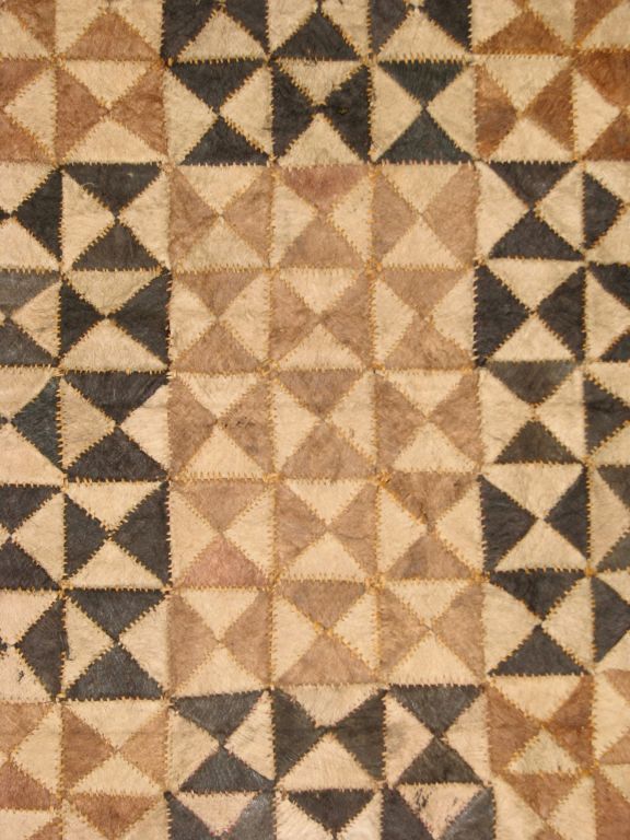 A fine example of an early 20th century Demoratic Republic of  Congo (formerly Zaire and the Belgian Congo) Kuba bark cloth skirt or status cloth made up of  triangular pieces joined together in a dark and light pattern of squares.