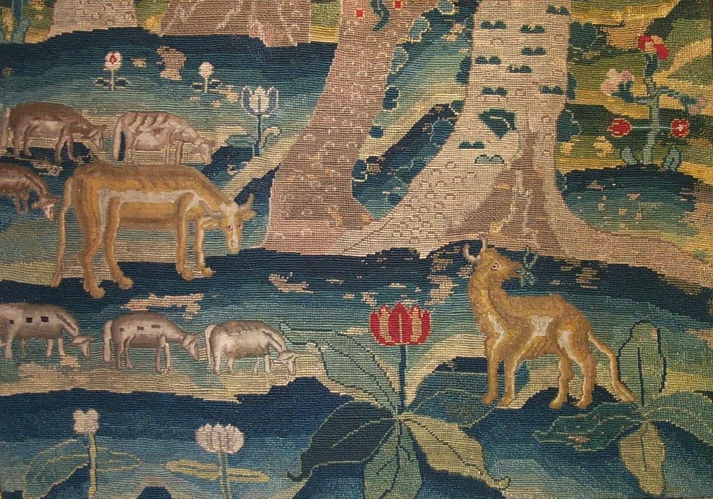 c.1725 English needlepoint panel in wool and silk depicting a charming grove of flowering trees with twisted trunks. Below the trees are naively drawn sheep and cows. In the background are typical stylized hills (hillyhocks) filled with flowers and