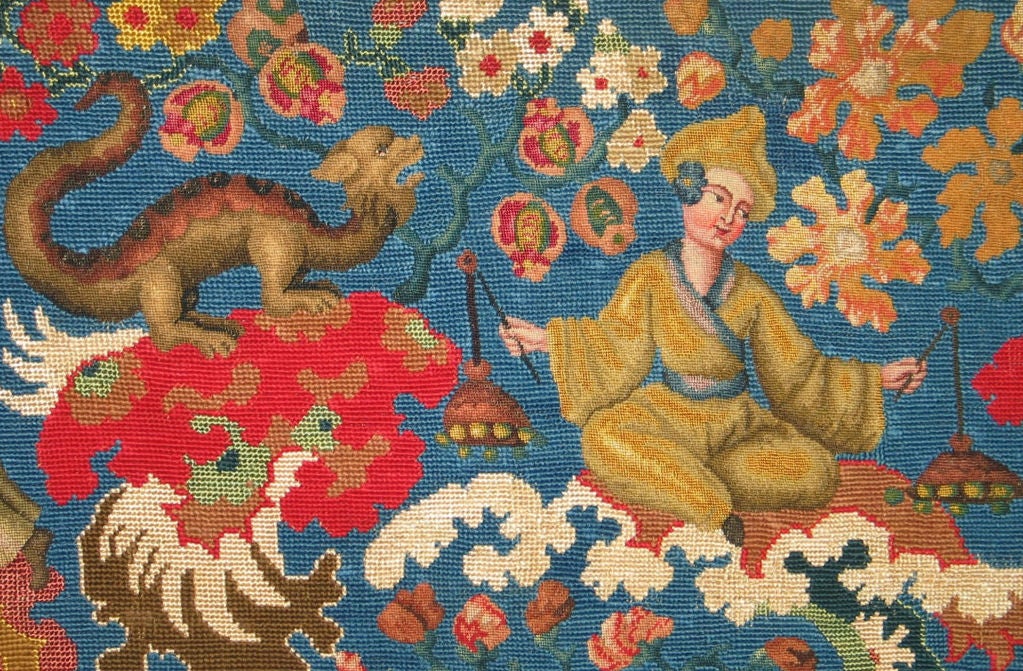 An exceptional 18th century French Chinoiserie needlepoint panel with a bright blue ground figured with Chinese stylized musicians with wonderful dragons nearby all amidst floral sprays.