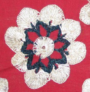 An early 20th century  Sind, Pakistan red cotton ground shawl embroidered in white and blue untwisted silk threads in a repeated floral pattern.  The borders are embroidered with the same color threads in patterns of flowering trees.
