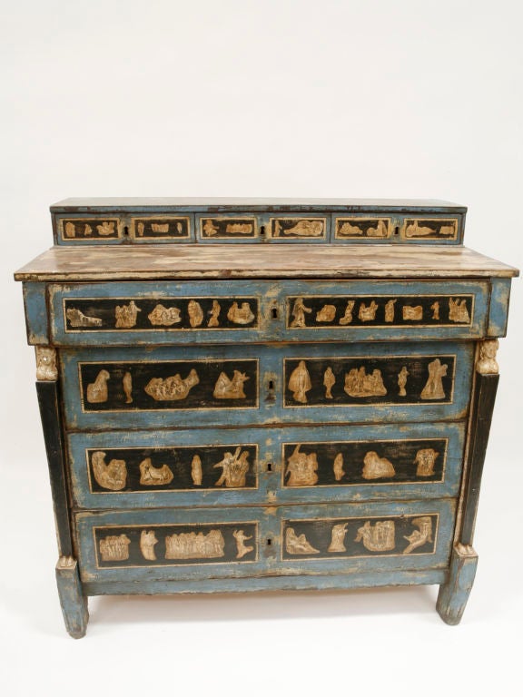 This highly unusual wood chest still has original blue and black paint with decoupaged embellishments on drawer fronts and chest sides.  The corners are decorated with small carvings of busts and feet.  Really beautiful.
