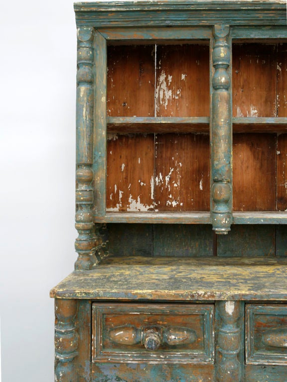 The charm of this country cupboard comes from its turned styles, carved panels, and many layers of old paint.