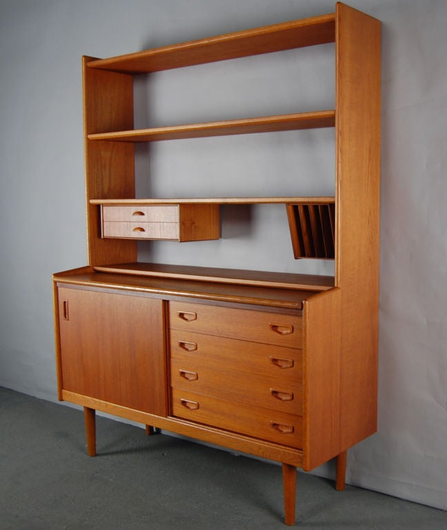 Teak credenza with pull-out desktop with adjustable upper shelves, drawers and cubbyholes.  Lower section has sliding cabinet door with two interior shelves and four ample exterior drawers.  <br />
<br />
Please contact us with any questions!