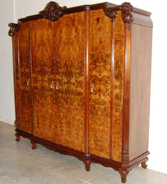 Large restored Swedish armoire or wardrobe of gorgeous book-matched burl walnut with golden birch interior.  Interior hanging rods, mirrors and drawers make a complete closet.  Very heavy and very sturdy, this piece disassembles for easy moving and