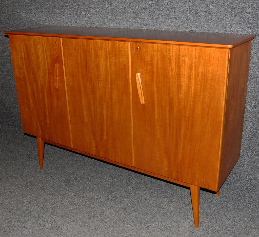 Stylish and sturdy three-door credenza crafted of rich oiled teak. <br />
<br />
Interior shelves and pair of drawers are not adjustable.<br />
<br />
Original key included.<br />
<br />
Please contact us with any questions!