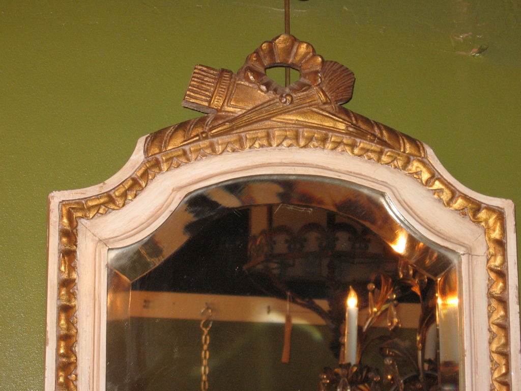 Pair of Crème and Parcel Gilt Mirrors having torch and ribbon form crests and gardrooned borders.  Attributed to Sue Et Mare.