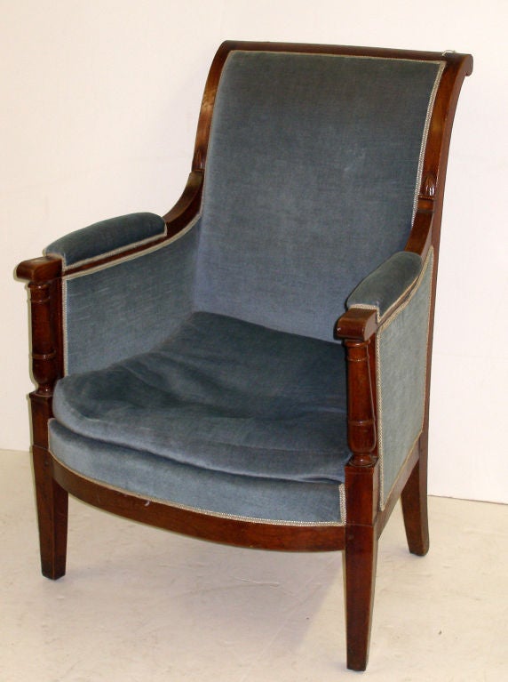 French empire bergere armchair having blue upholstery and mahogany wood.