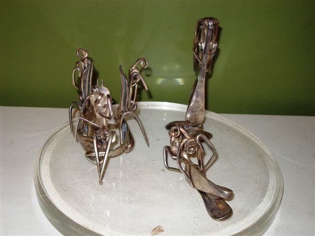 Three silver abstract figures(created from flatware) with a lucite base and glass dome.<br />
Dome - 10