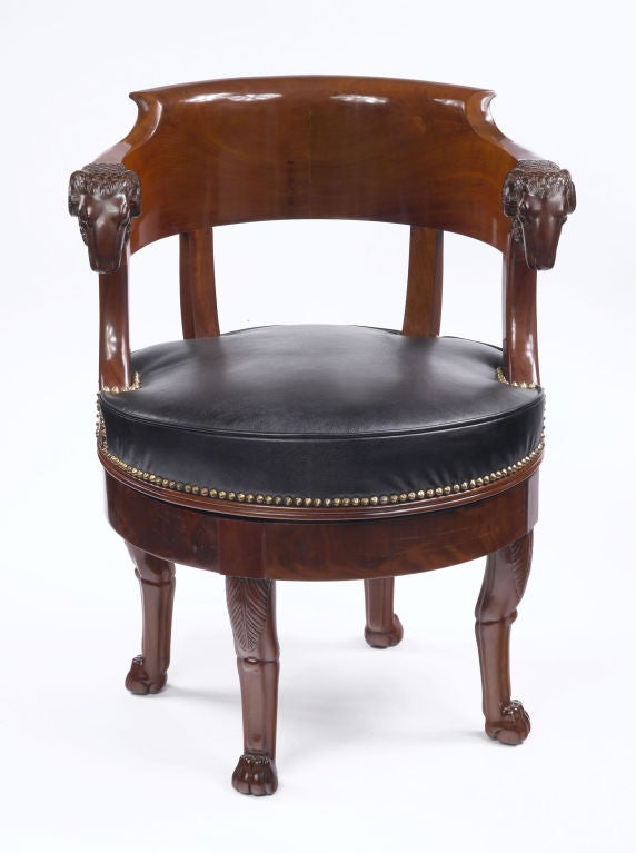 An important and rare French Empire period, mahogany fauteuil de bureau à assise tournante with a gondola shaped back and a leather swivel seat attributed to François-Honoré-Georges Jacob-Desmalter. There is an exceptional carved ram’s head at each