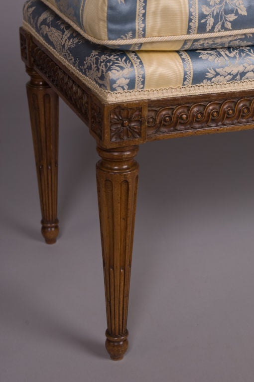 A French Louis XVI period, beechwood banquette stamped twice on each bottom rail, “JB BOULARD”, by Jean-Baptiste Boulard, who became a master joiner in 1755.  The banquette has a close, tight seat with loose cushion above a guilloche-carved seatrail