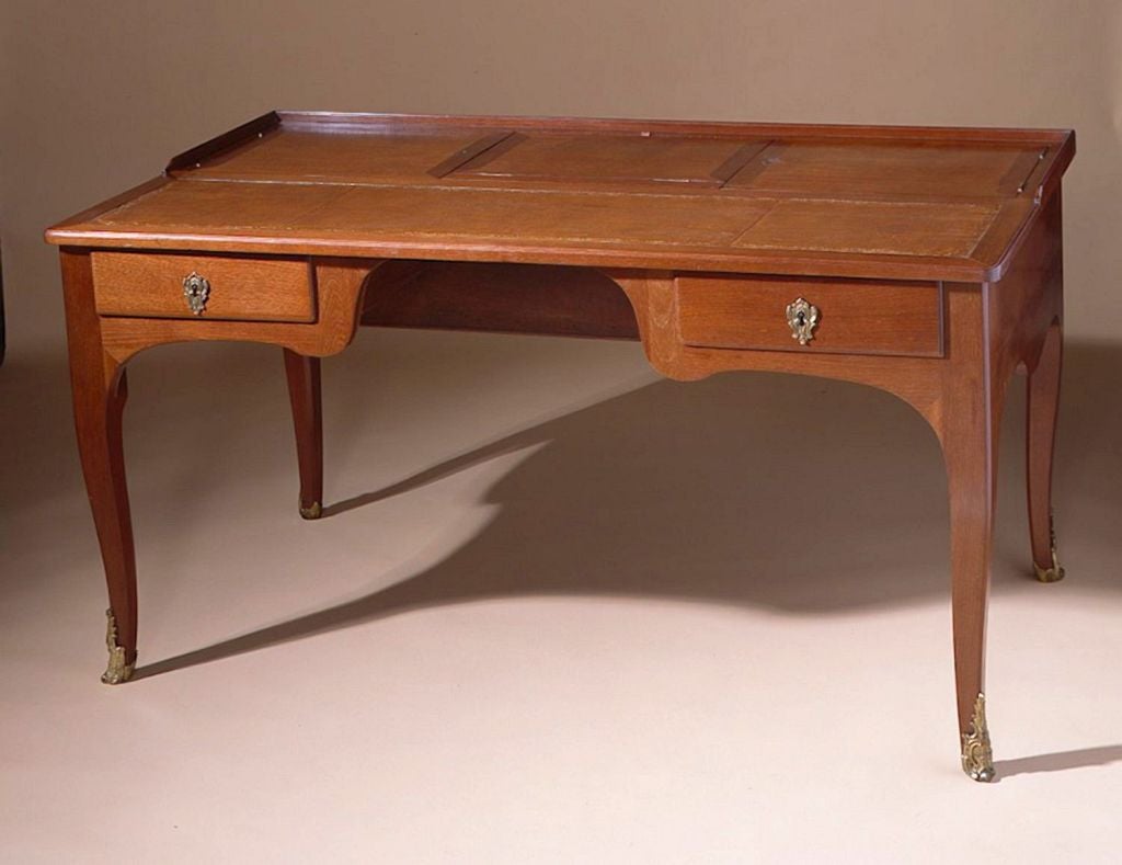 An important and rare French Louis XV period bureau plat made of solid mahogany, mahogany veneer, and oak.  The piece represents the beginning of the use of mahogany during the beginning of the reign of Louis XV.  It is a piece of furniture that is