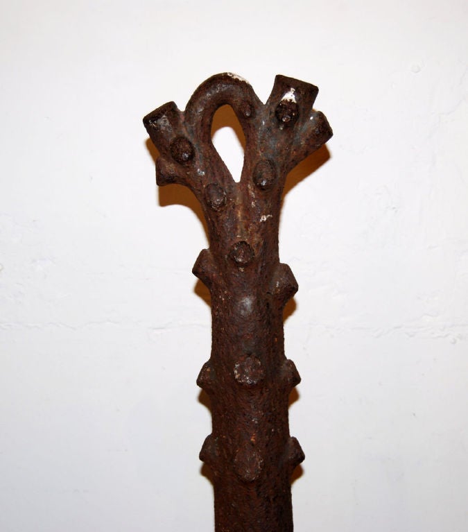 Cast iron hitching post shaped like a tree branch. It has been mounted to an iron base to make it safely free standing.