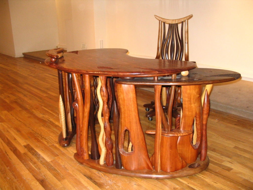 A desk and matching tall back chair in the Studio Movement. the desk is surreal when viewed in person. A truly one of a kind desk.Having many different species of exoctic woods surrounding a massive and perfect  mahogany top. The top has  inlay