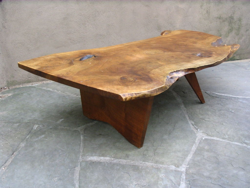 This is  a wonderful untouched coffee table by studio Movement artist George Nakashima. Thick and massive walnut top,having a great free edge with small burled sections and all of nature