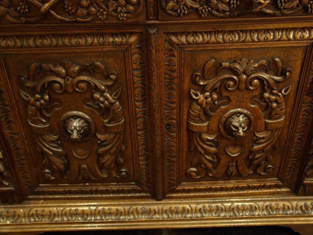 Highly carved 2 piece oak china cabinet in the late Victorian Renaissance Revival style.  Spectacular carvings depicting lion heads and botanical details.