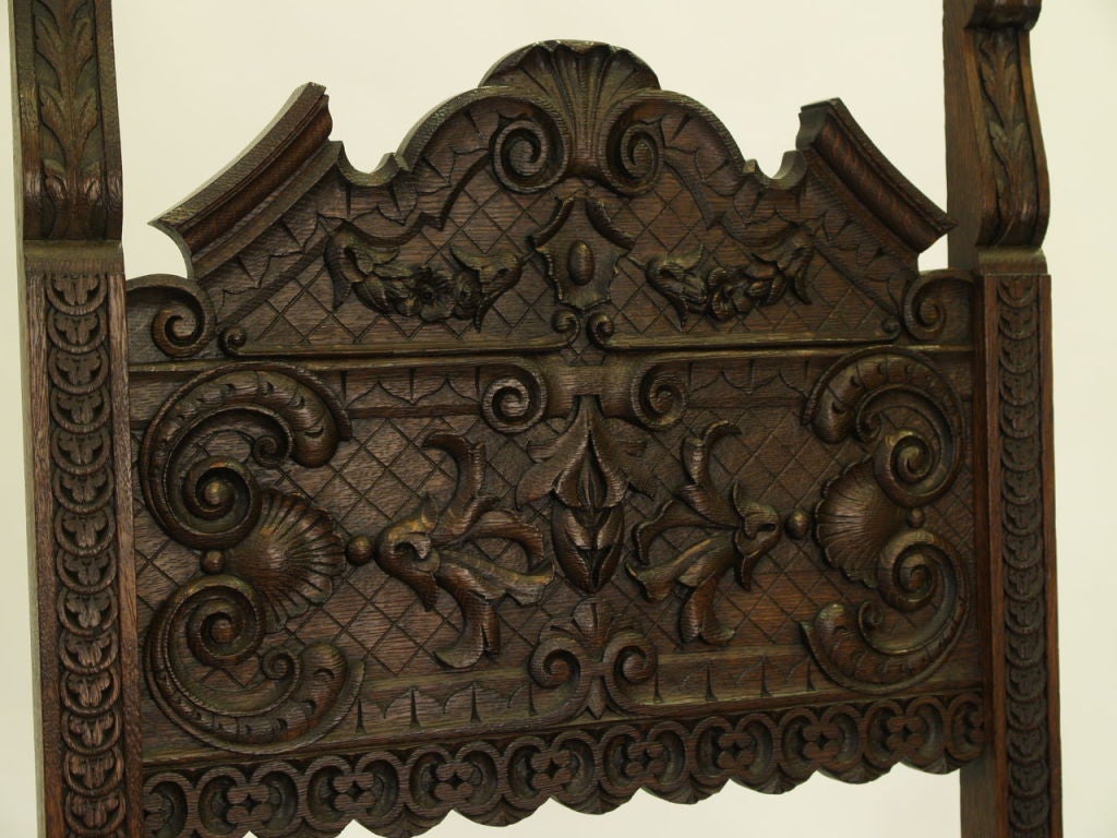 Tall and impressive carved arm chair in solid oak with the original deep tone finish.  This item was in prior inventory at 20th Century Fox Studios in the 1930s-1940s. Interesting marks underneath the seat reference this bit of legend.