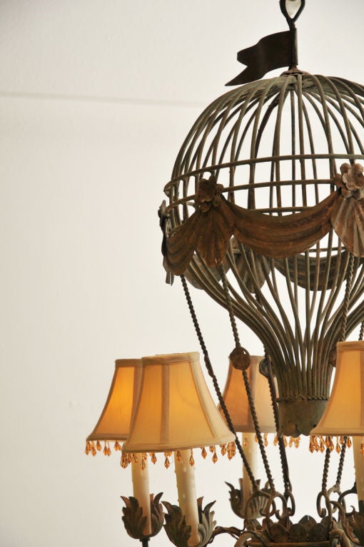 This Chandelier is formed as a Hot Air Balloon , with painted metal and bronze patina, together with six arms (electrified),  shown with six fabric shades in bone , looks great with or without. The overall color has a green  patina  accented with