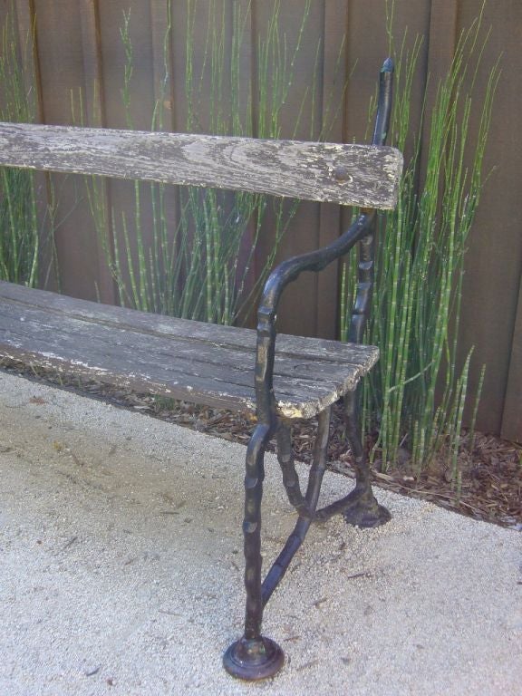 Vintage wood and iron bench from the 19th Century. Very unique arm and legs. Vintage condition.