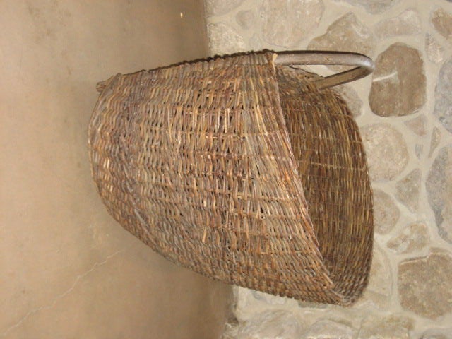 Woven straw basket from Belgium, c. 19th century. Half round shape with a curved wooden handle. Vintage condition.

