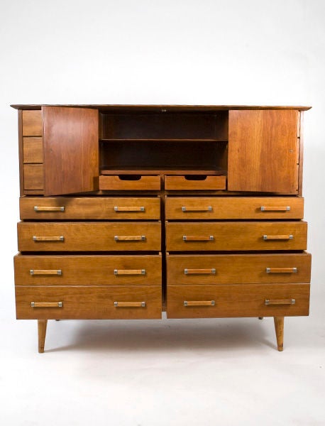 A fourteen drawer chest with a center cabinet containing two shelves and two drawers. Manufacutred by the Johnson Furniture Company with John Stuart label.