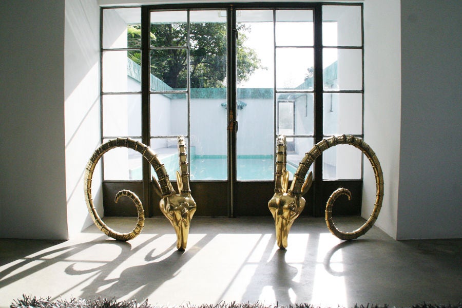 Massive solid heavy brass rams heads dining table bases, can also be used as floor sculptures. Modernist face with nubby details throughout rams horns. Brass has been polished with a protective coat so they will never tarnish.