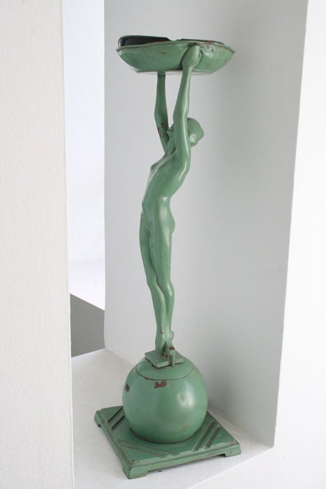 Frankart nude ashstand, c. 1930's. Original green paint over bronze, tall sexy woman holding an ashtray, which has a glass ash tray on top, she stands on a sphere, which is secured onto a steel 7