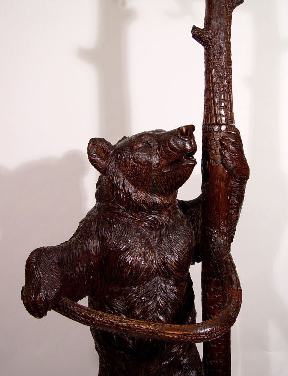 A Black Forest Linden Wood Bear Hallstand, <br />
Switzerland,<br />
Circa 1870<br />
<br />
The hallstand in the form of a powerfully modelled mother bear shaking a tree in which her three cubs are climbing playfully.<br />
<br />
The bears