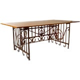 A fine Art Nouveau period rusted iron table base with walnut top