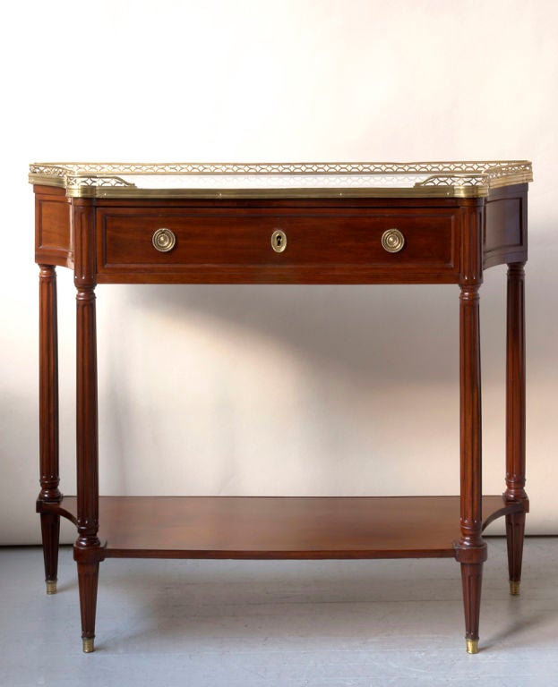 A Louis XVI period mahogany console desert with concave sides , marble top with bronze gallery,one drawer, and  lower  shelf , French c. 1790<br />
Width-40½