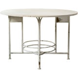 A white painted iron table base with white travertine top
