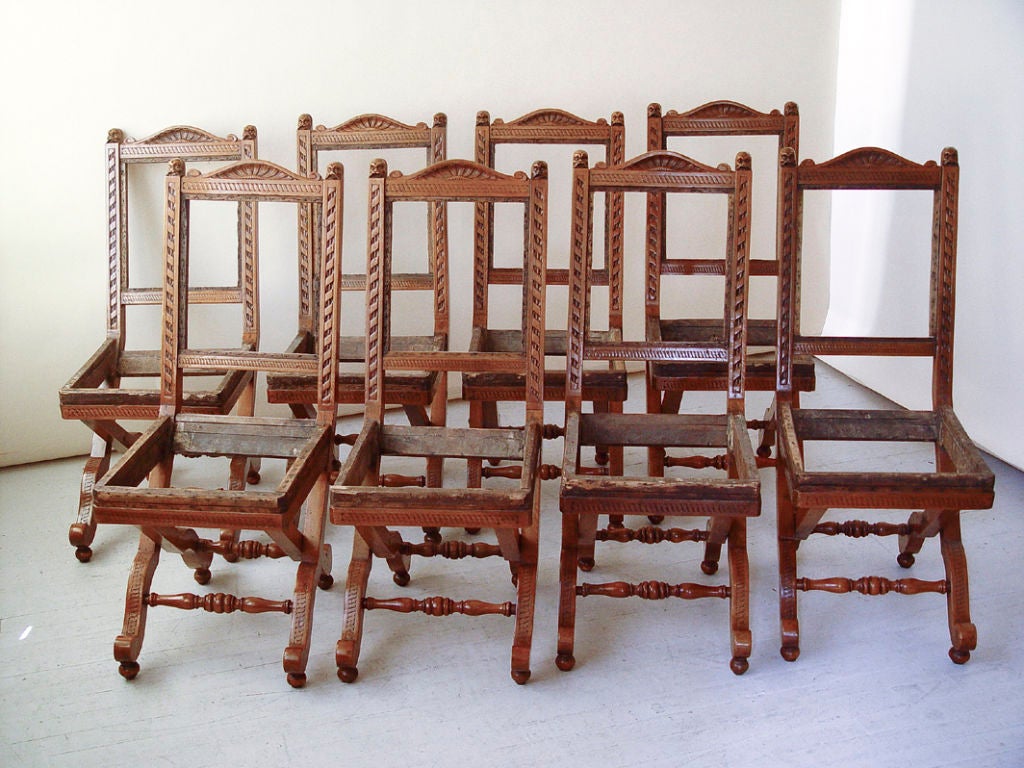 An unusual set of eight carved walnut side chairs, in a simulated folding style with X-shaped legs and a turned wood stretcher base, French, 19th century, in frame not upholstered, as is

Measures: Width 15 ½
