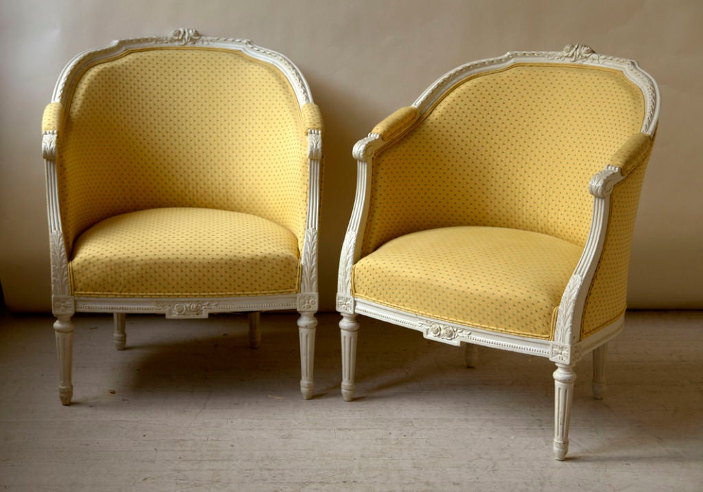 A pair of white painted Louis XVI style bergeres, Continental, 20th century<br />
Width-27½