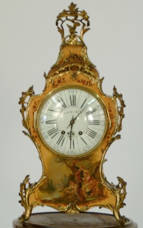 French Polychrome Mantle Clock from Lyon, late 1800's.  The crest with elaborate pierced brass foliate and bird motif over a symmetrically shaped brass foliate enhanced case adorned with a hand painted scene of two ladies and a gentleman enjoying