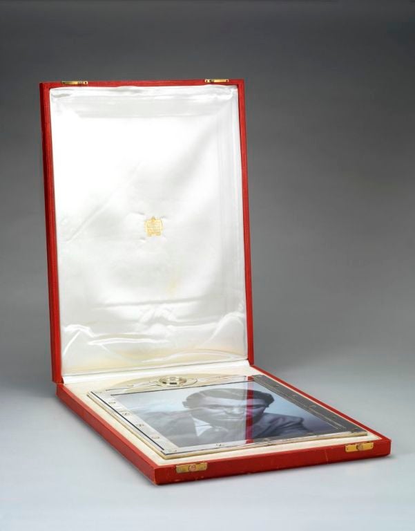A magnificent Sterling silver Art Deco photograph frame of massive proportions (19 inches tall!) the silver border with 18ct gold 'screw' detail, the arched top incorporating a Cartier 8 day, Swiss made timepiece, complete with original red leather