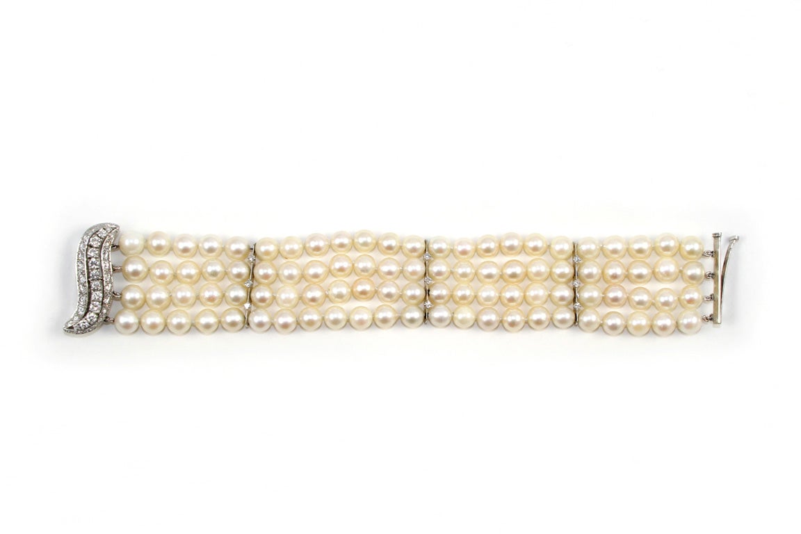 Four Strand 7 1/2mm. Cultured Pearl Bracelet separated with 3 Diamond Bar Spacers, and with elaborate Diamond & Platinum 3 row Swirl Clasp.Prong set.