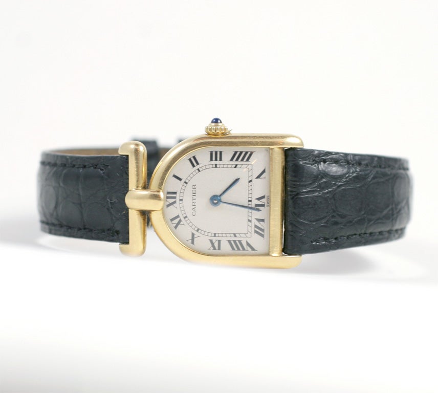 18kt Yellow Gold Horseshoe Quartz Watch with Leather Strap & Cabochon Sapphire Thumbpiece. Purchased in 1988 w Original Certification & Bill of Sale. Signed Cartier/Paris, Swiss Made, 18kt Quartz Numbered 810820218 & Bearing Swiss Hallmark.