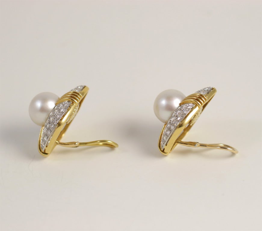Magnifica coppia di orecchini in oro giallo e bianco 18kt, ciascuno con una perla dei mari del sud di 13 mm e 48 diamanti bianchi e puliti a taglio pieno incastonati nell'oro bianco. Peso totale dei diamanti: Circa 9 carati. Ca. 1980. Gli orecchini