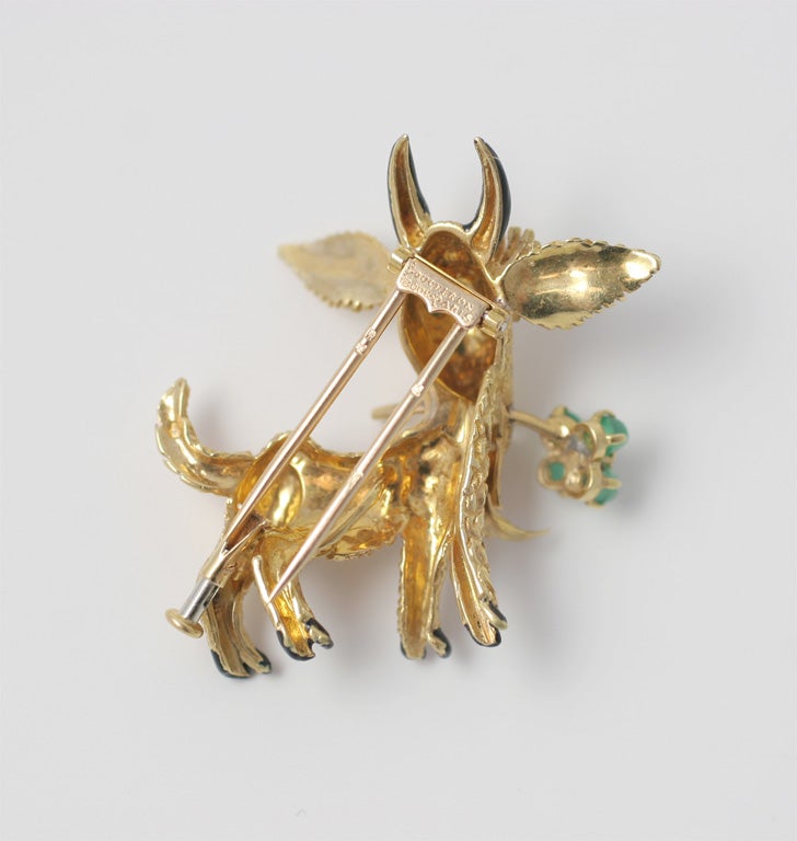 A whimsical scatter pin of a friendly goat with turquoise eyes and a chrysoprase and diamond four leaf clover in his mouth.