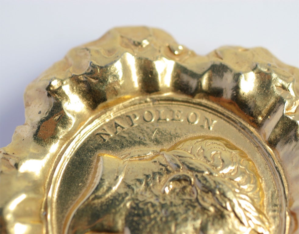 Large brooch shaped as a gold nugget coin.