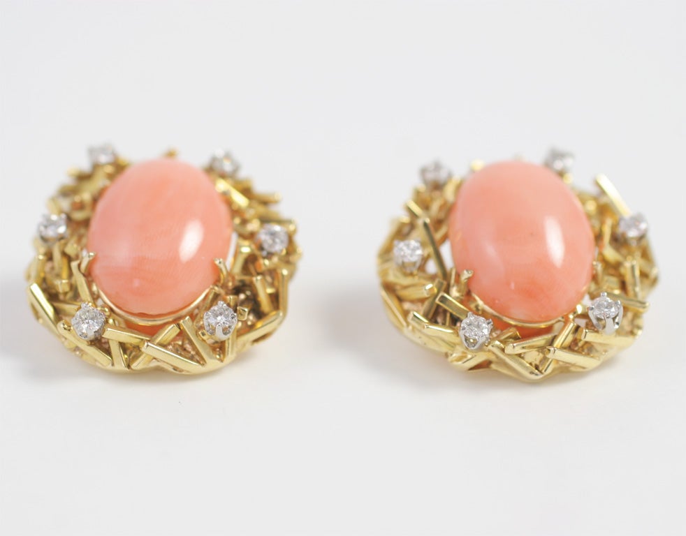 A lovely pair of earrings: delicate and feminine.  The coral on these earrings is known as Angel Skin, due to its creamy peach tone. The stone is surrounded by stylized gold branches and diamonds.