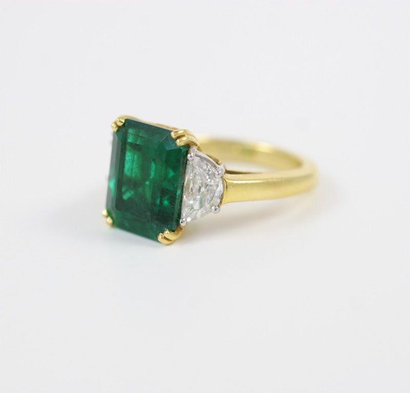 Emerald cut Emerald 6.03 carats
2 half moon cut diamonds 0.90 carats
Must be seen to appreciate the color