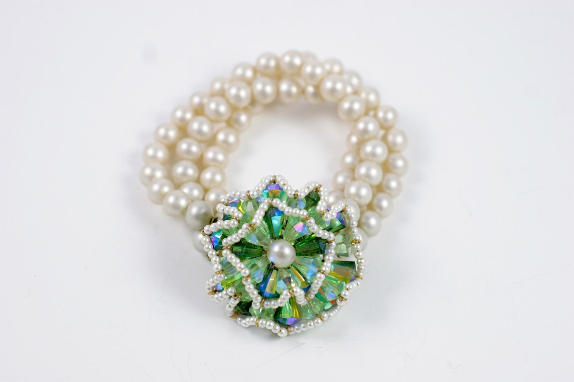 Pearl bracelet with large green stone and pearl floral clasp.