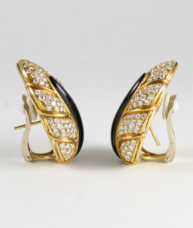 Paire de grandes boucles d'oreilles en forme de feuille, pavées de diamants. Environ 8,5/9 cts de diamants blancs de pleine taille, sertis en pavé. La tige centrale est en onyx sculpté et les feuilles sont segmentées par de l'argent jaune de 18kt.