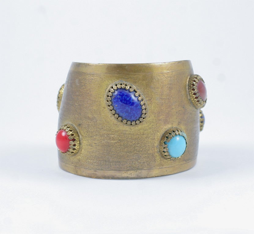 Antique brass finished cuff adorned with faux semi precious cabochon stones.
