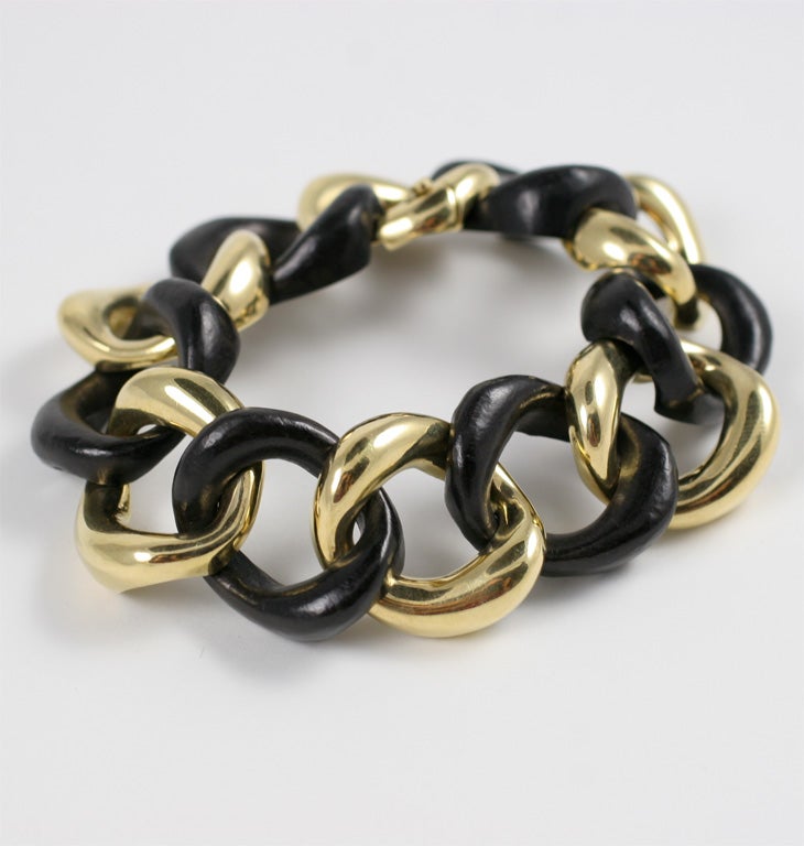 18kt Yellow Gold and  Ebony Wood Link Bracelet with self closing hinged link.  The bracelet can be made any length.  It measured approximately 1 inch wide.

This classic bracelet is also available in White, Amethyst, Onyx, and Tigers Eye.