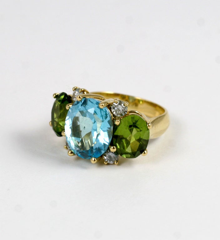Christina Addison Bespoke Large 18kt yellow gold Gum Drop ring with blue topaz (approximately~ 8 cts), peridot (approximately ~5 cts each), and 4 diamonds weighing ~0.40 cts.

Specifications: Length: 15/16