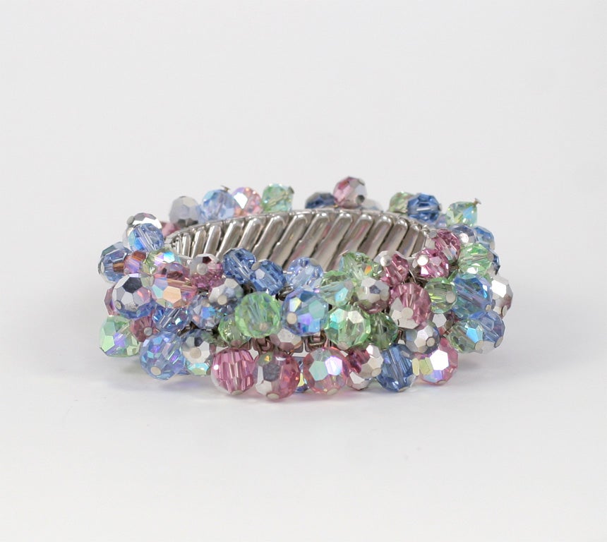 Pink, green, and blue crystal dangling beads on a stretch metal bracelet.