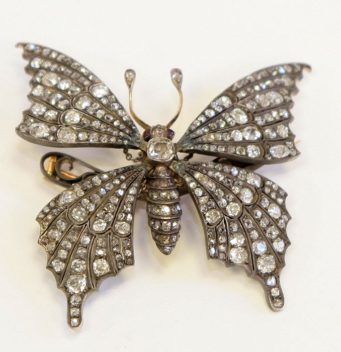 fabulous 19th century silver on gold and old mine cut diamond butterfly brooch with spring loaded movable wings measuring wing tip to wing tip 2.5 inches and from wing tip to wing tail 2.75 inches.