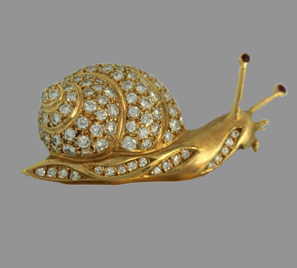 A beautifully modelled diamond and gold snail pin with ruby set antennae by Mauboussin Paris.
