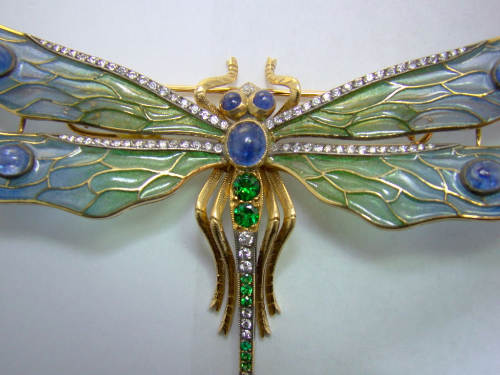 Gorgeous 18K yellow Gold handmade plique-a-jour dragonfly, studded with seven cabachon Sapphires, 86 round cut Diamonds and 13 Tsavorite Garnets.